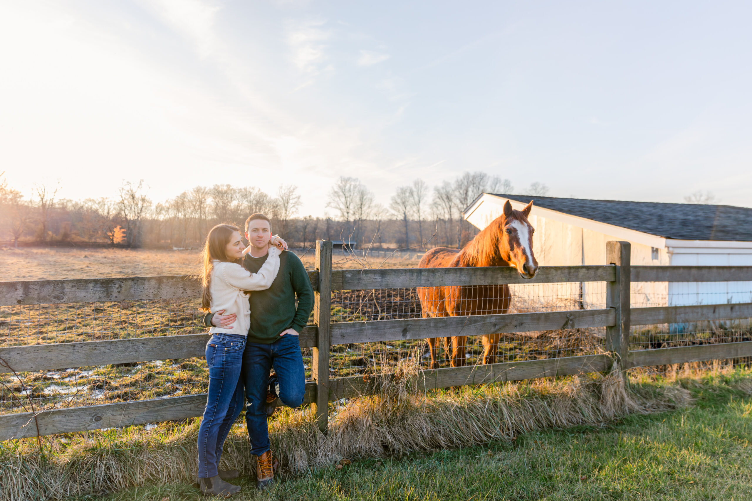 Couple on a farm with a horse in the background