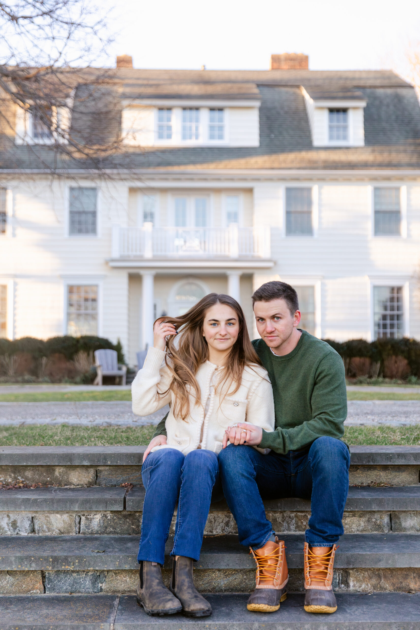 Couple sitting in front of a white house