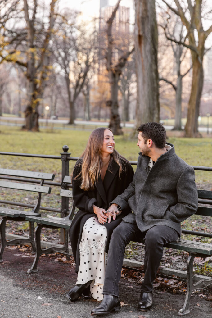 Couple laughing on a bench in central park