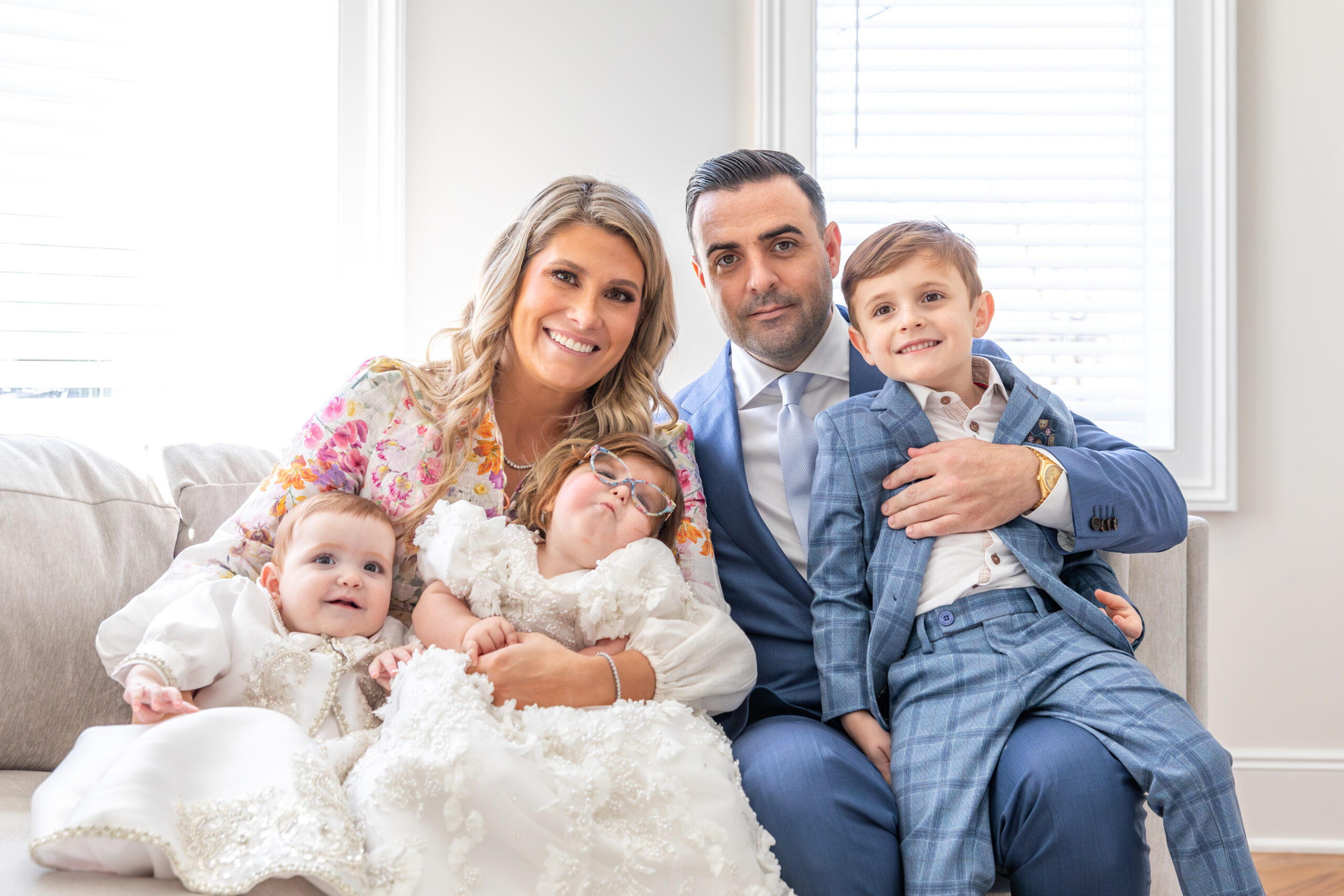 Family photo on comfy white couch. Holy Rosary Church Baptism