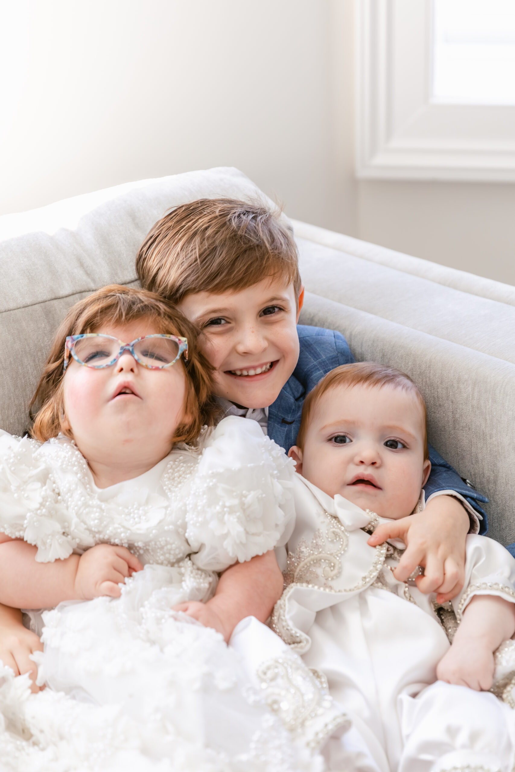 Sibling photos on a comfy couch 