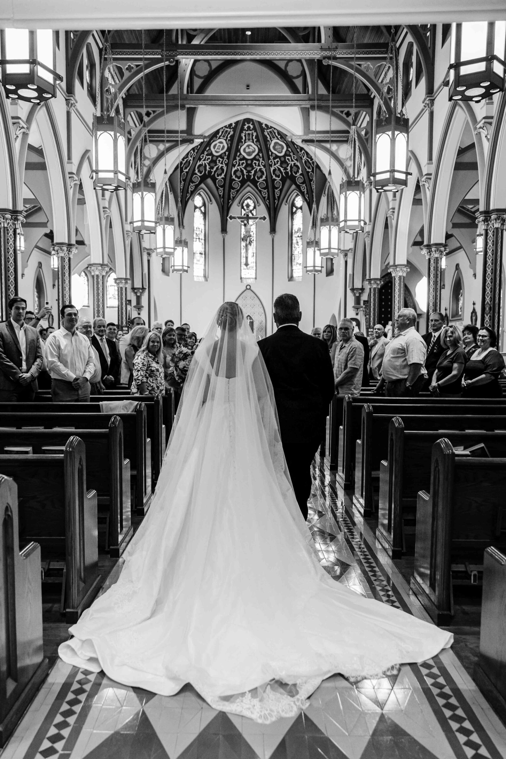 black and white photo of bride walking down the aisle