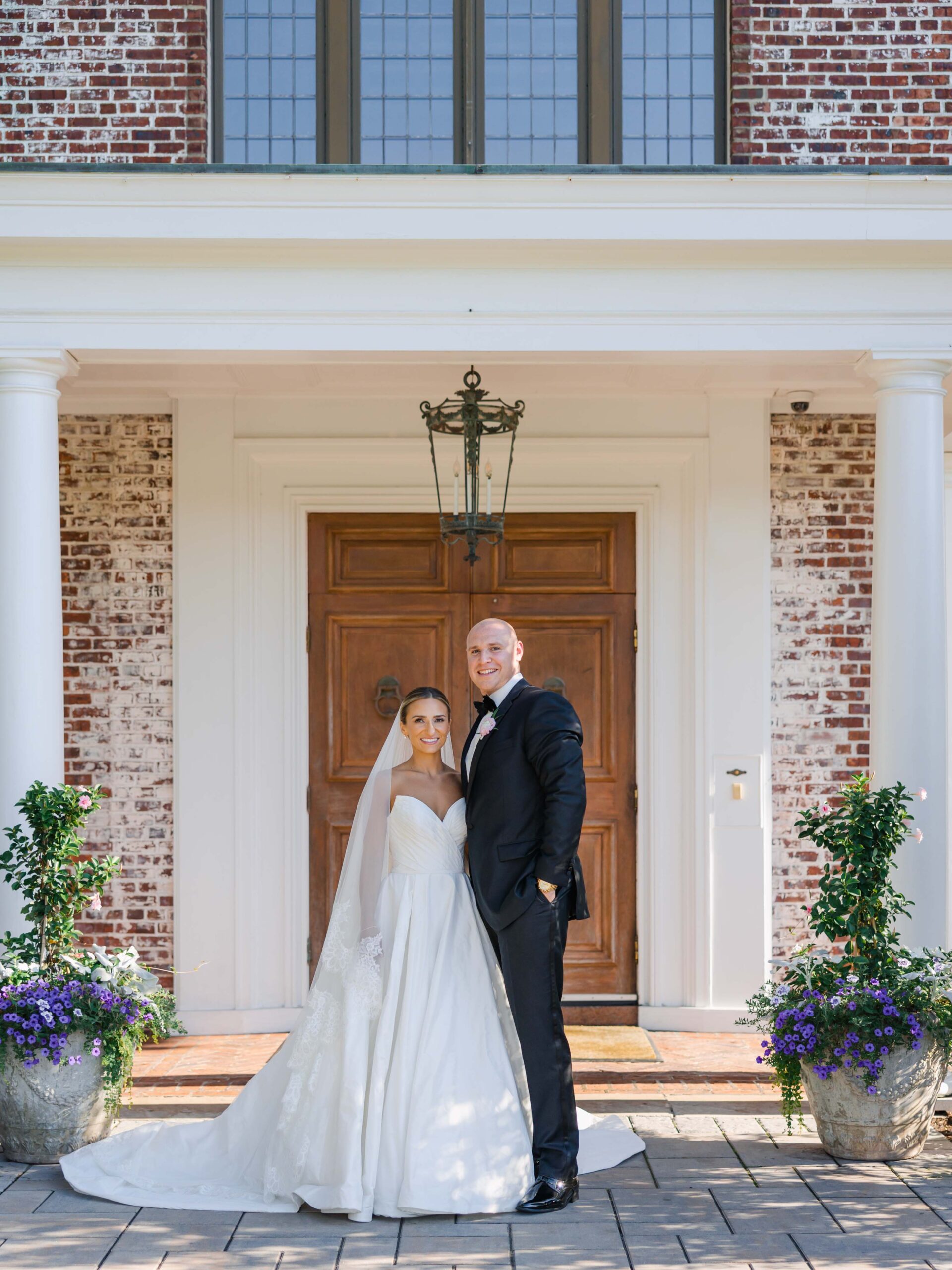bride and groom pose in front of venue door