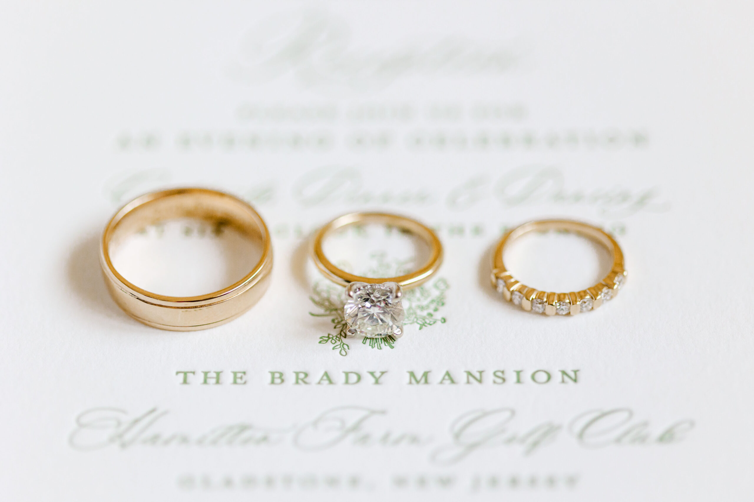 gold wedding bands photographed on invitation