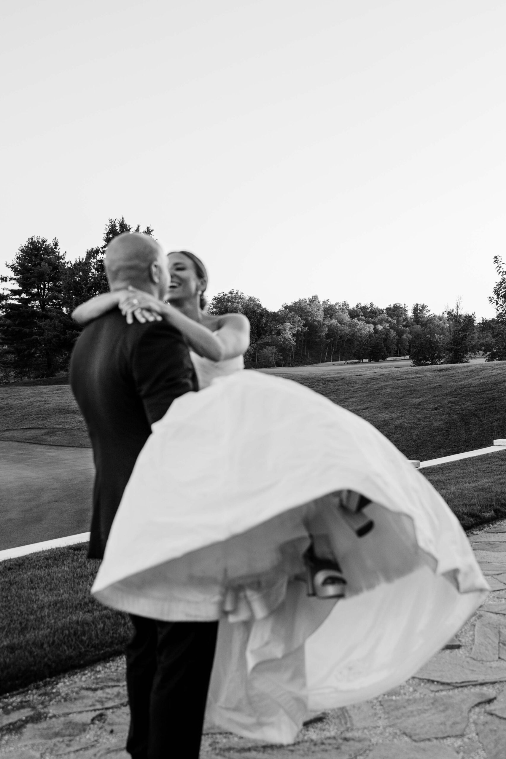 black and white blurry image groom carrying bride