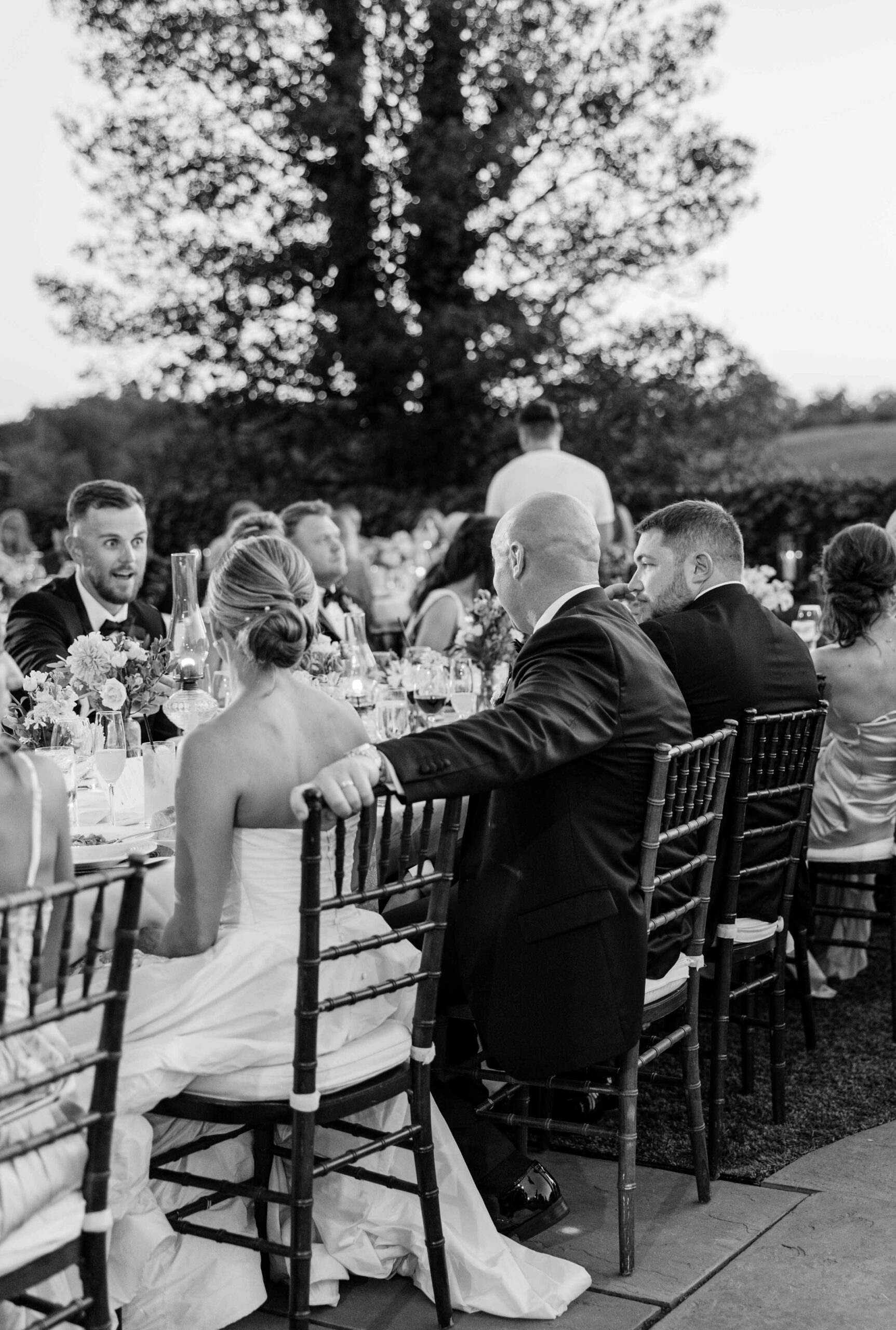 bride and groom sitting together at al fresco wedding reception