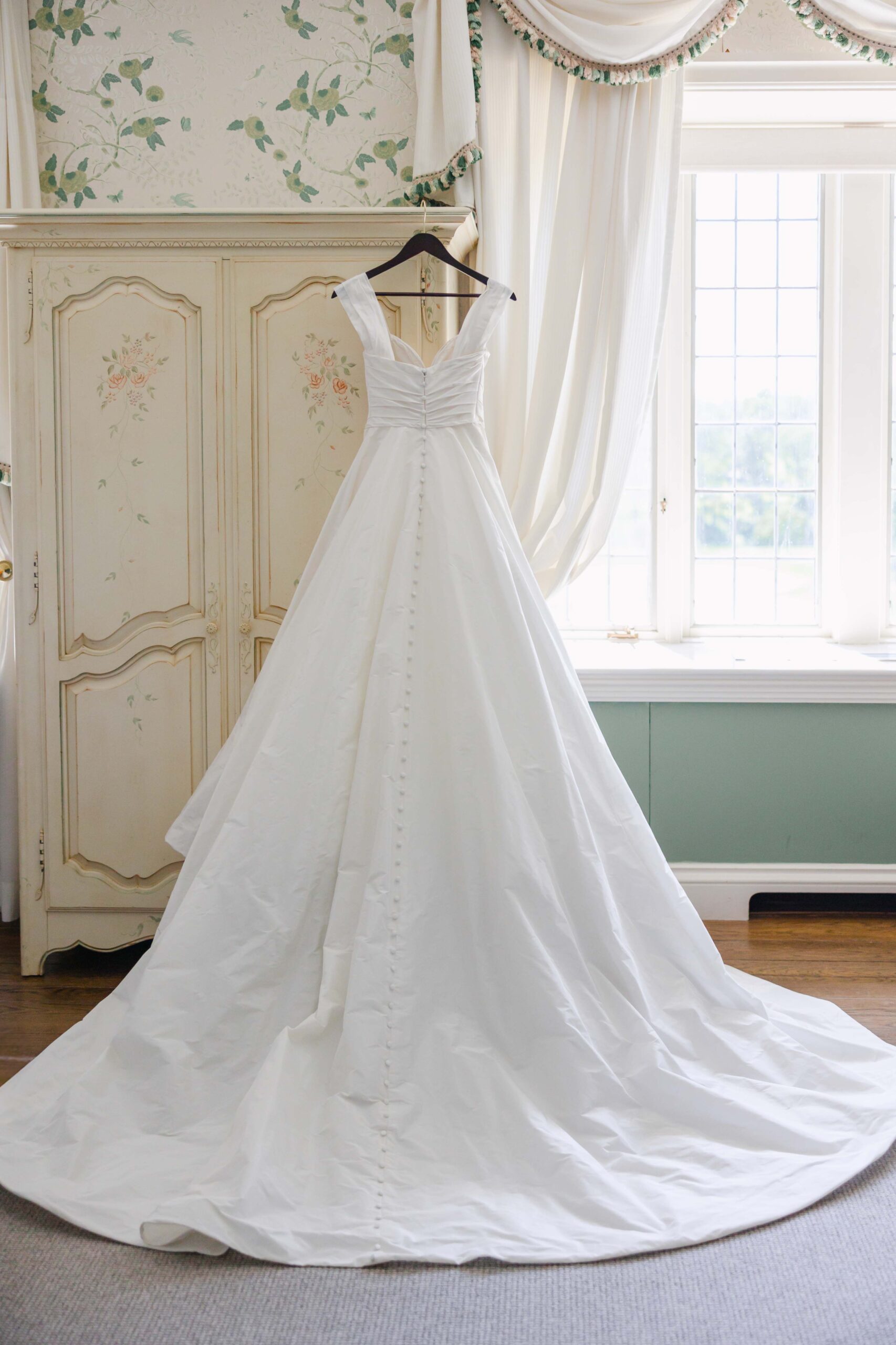 back of wedding dress hanging on armore