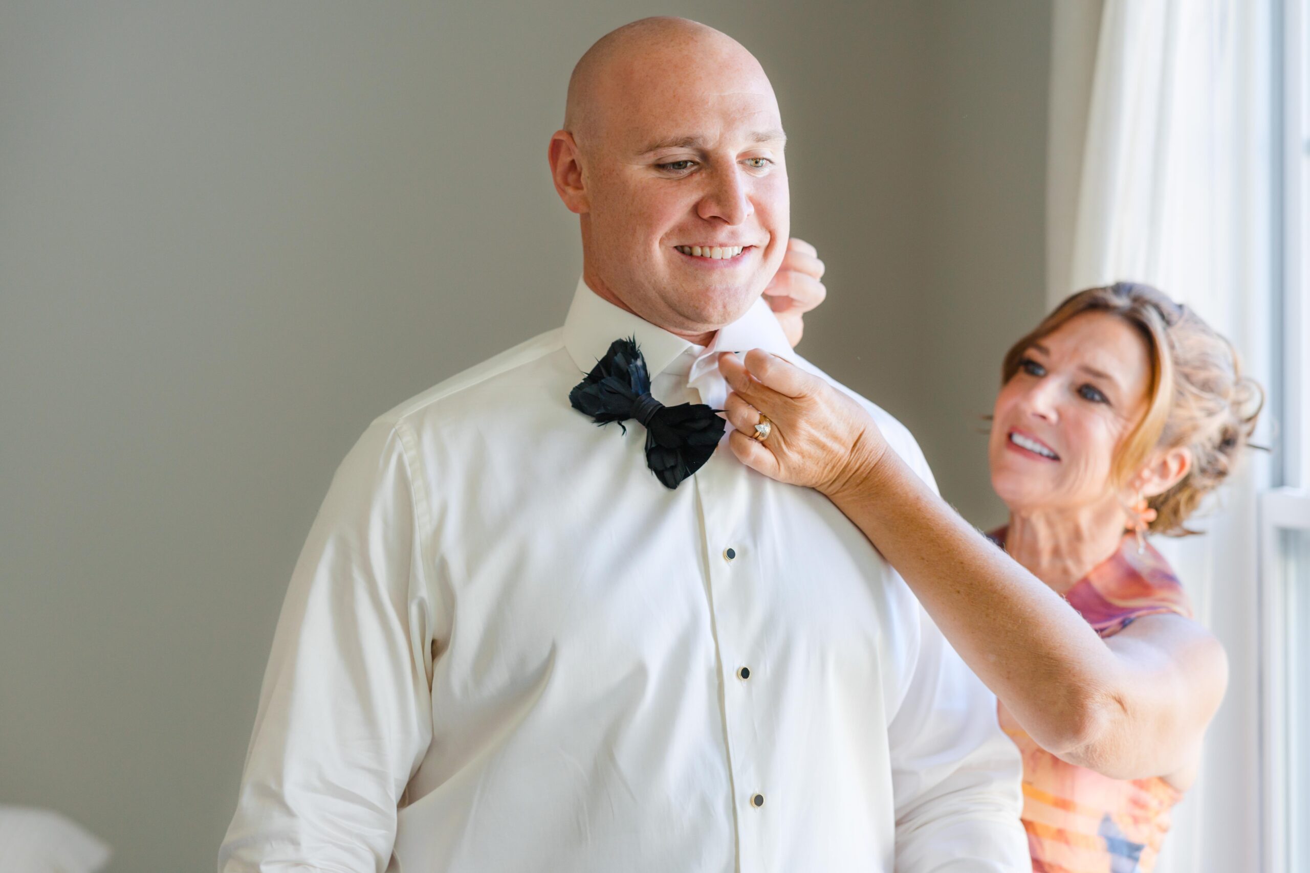 mom pinning grooms bowtie